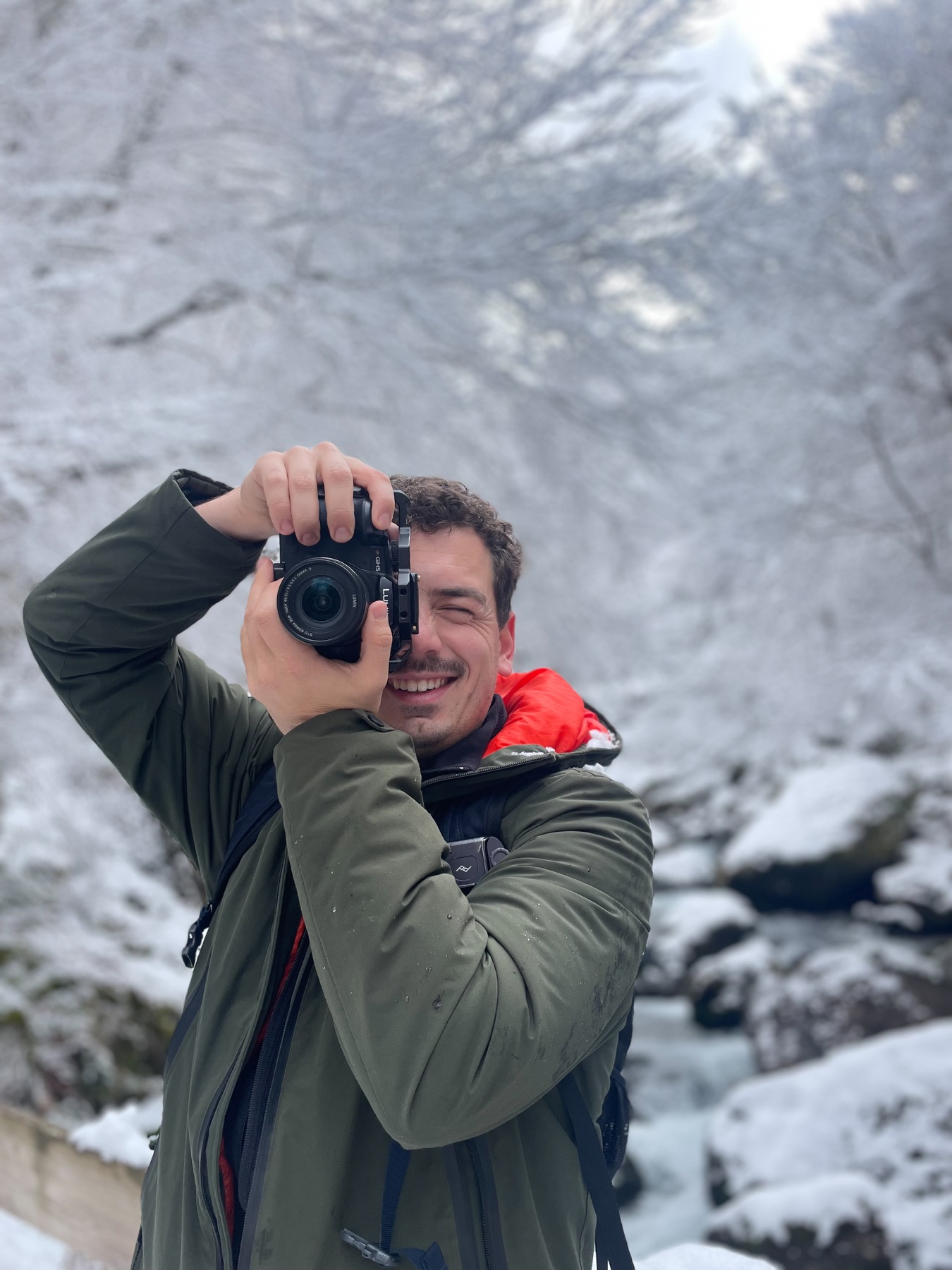 Camille Cassaigne photographiant dans un paysage enneigé