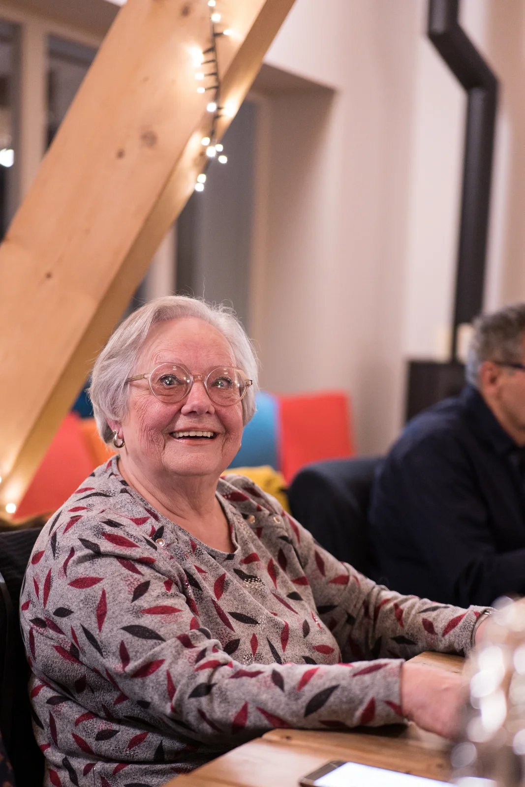 Une grand-mère éclate de rire au milieu d’un repas de famille.