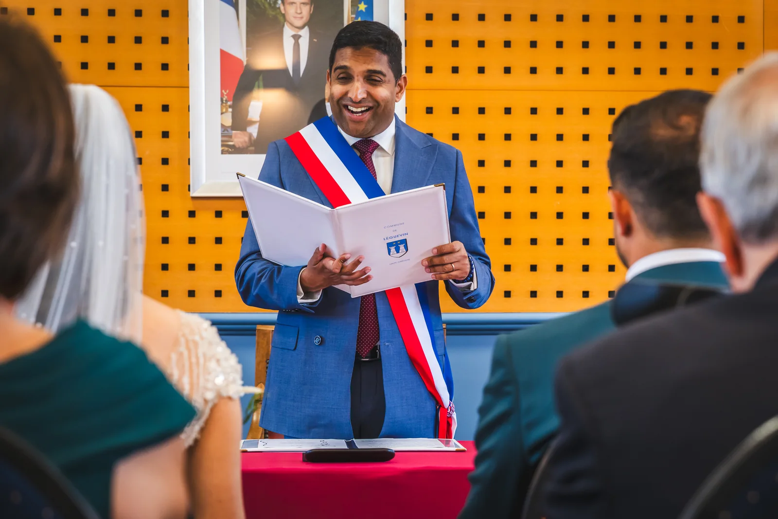 L’officiant sourit aux mariés pendant la cérémonie civile.