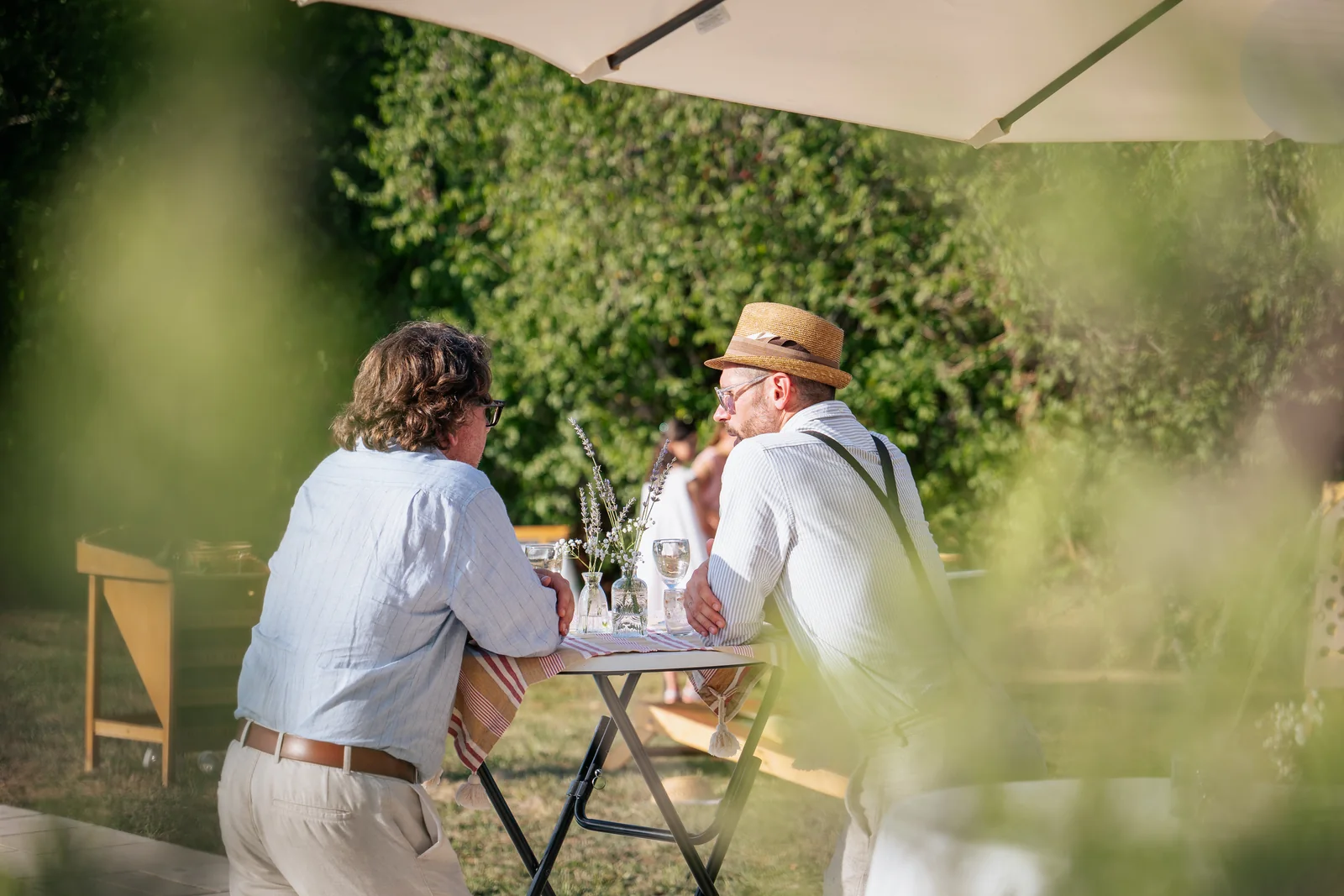 Deux invités échangent autour d’une table pendant le vin d’honneur.